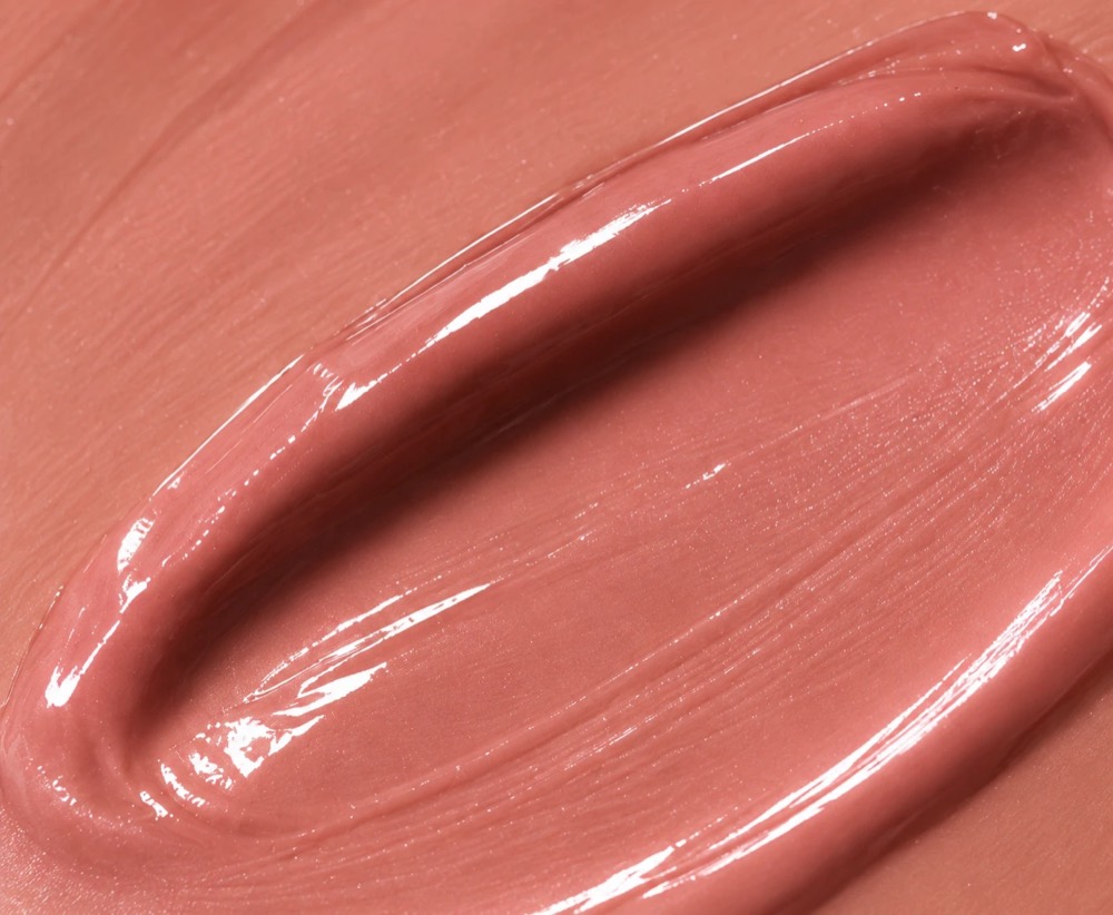 A cream blush swatch swiped across a warm surface